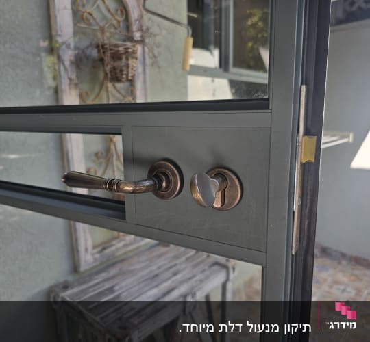 ידית דלת מתכת עם מנעול על דלת זכוכית